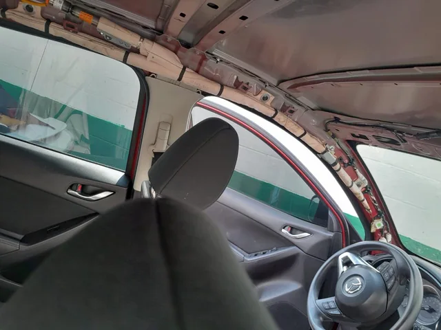 Interior de Mazda con el revestimiento del techo retirado y componentes SRS visibles